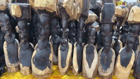 Display of carved wooden tribal sculptures of human figures with distinct facial features and stylized bodies. - Powered by Shutterstock - Get 15% off with code: PIKWIZARD15