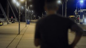 Man finishing a run with arms raised in celebration on an illuminated city street at night. Triumphant moment of a runner achieving a personal goal under urban lights. - Powered by Shutterstock - Get 15% off with code: PIKWIZARD15