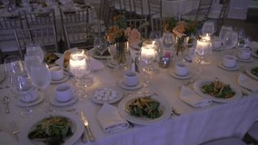 A beautifully arranged dinner table set for a formal event, featuring lit candles, elegant glassware, and floral centerpieces. Fresh salads on fine china plates add a touch of sophistication. Ideal fo - Powered by Shutterstock - Get 15% off with code: PIKWIZARD15