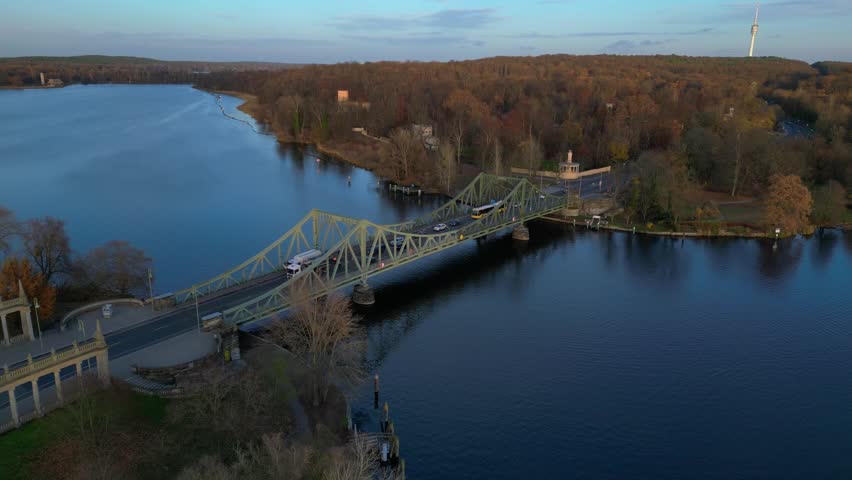 glienicke bridge over the havel river, with cars driving on it during a colorful autumn sunset. Gorgeous aerial view flight descending drone