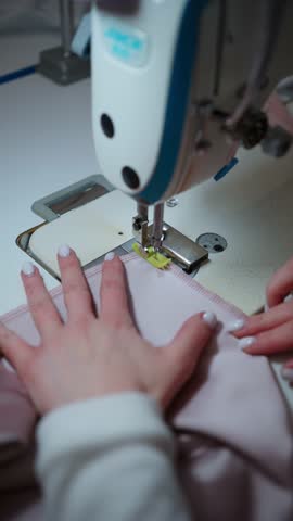 Seamstress that guides fabric during sewing. Concept of sewing clothes on sewing machine.