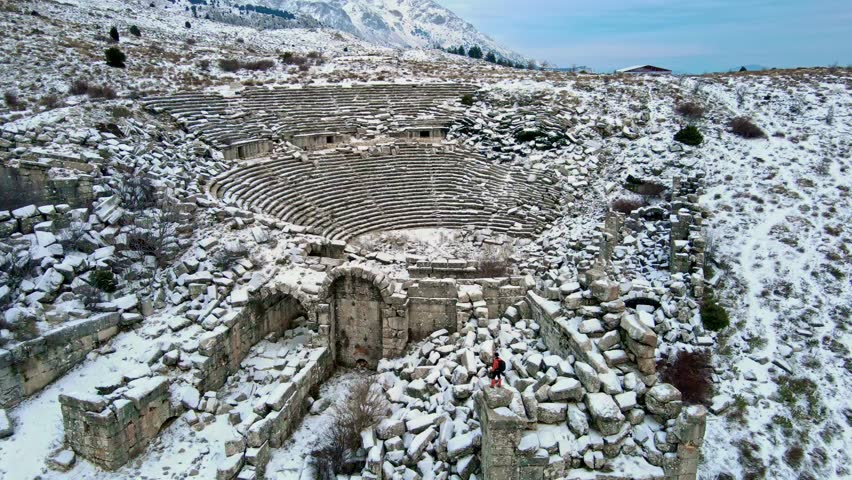 

In the ancientancient city of Turkey a photographer stands on snow-covered stone blocks,capturing the surrounding historic structures. The details of the stones and the snowy landscape take center