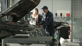 Female Manager Discussing Vehicle Repair with Mechanic in Auto Repair Shop - Powered by Shutterstock - Get 15% off with code: PIKWIZARD15