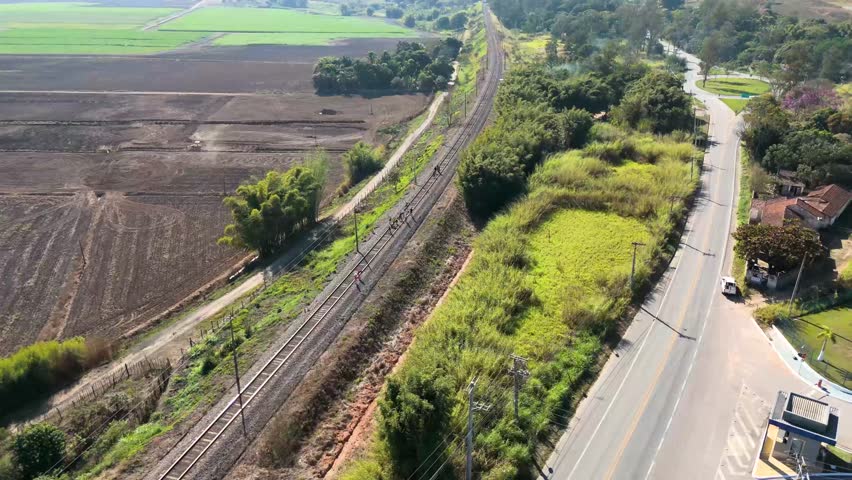 Drone View of people walking along railway tracks in a rural area in Brazil