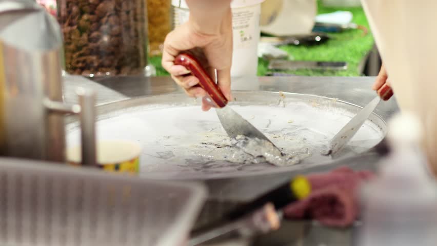 Hands crafting ice cream at a night market