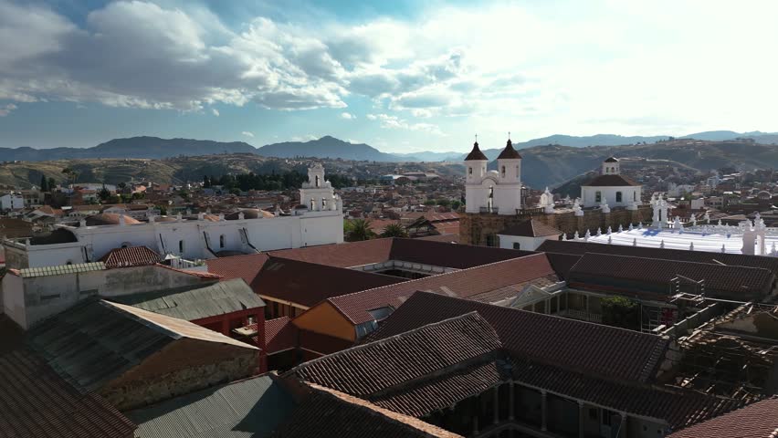 Aerial footage of Sucre, Bolivia, gliding through the historic town and passing Iglesia de San Felipe de Neri. The scene captures the town