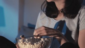 Night movie. Home entertainment. Amused laughing woman enjoying watching comedy show on TV laughing eating popcorn in bed late in dark room. - Powered by Shutterstock - Get 15% off with code: PIKWIZARD15