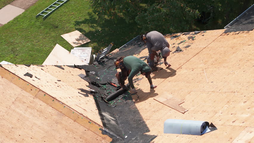 Element of Roofers installing a new roof on an building. Drone view