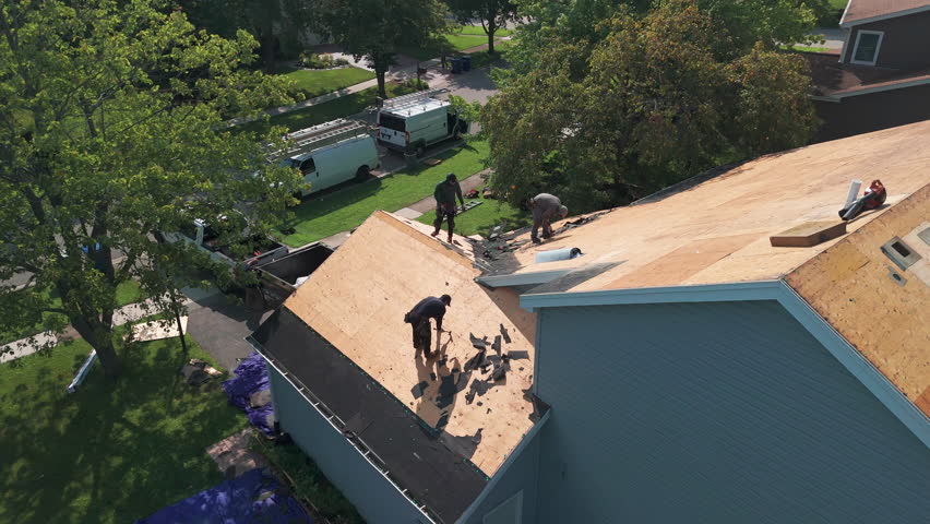 Element of Roofers installing a new roof on an building. Drone shot view