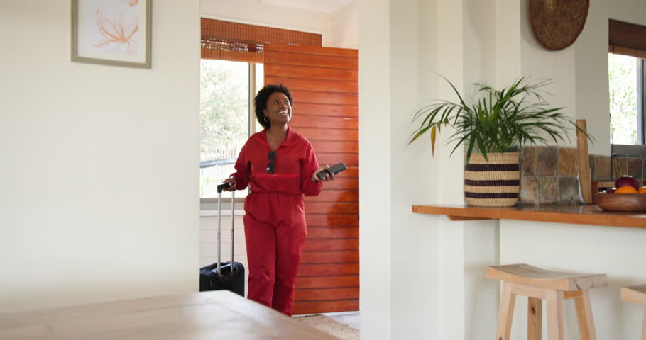 Entering home, three female friends carrying luggage and chatting happily. Travel, friendship, vacation, conversation, adventure, leisure