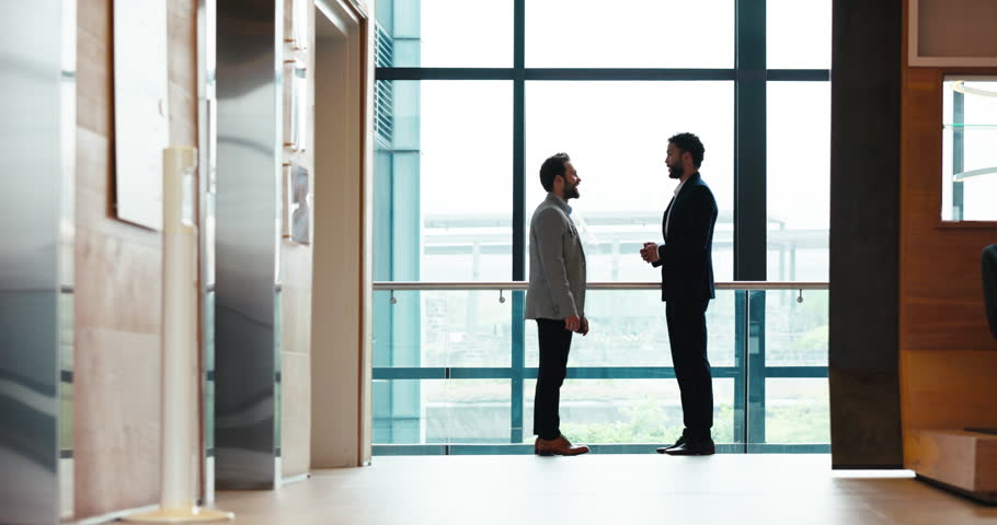 Businessmen, meeting and negotiation with handshake for partnership, b2b or introduction at office building. Business people, colleagues or employees shaking hands for agreement, teamwork or deal