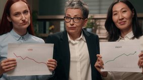 Mature businesswoman leader confused multiethnic women in office Caucasian girl holding chart bad result loss bankruptcy crisis and Asian lady graph good growth profit data papers diagram team finance - Powered by Shutterstock - Get 15% off with code: PIKWIZARD15