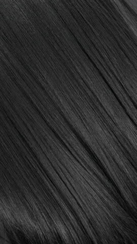 Vertical female long hair texture in slow motion, black straight hair background
