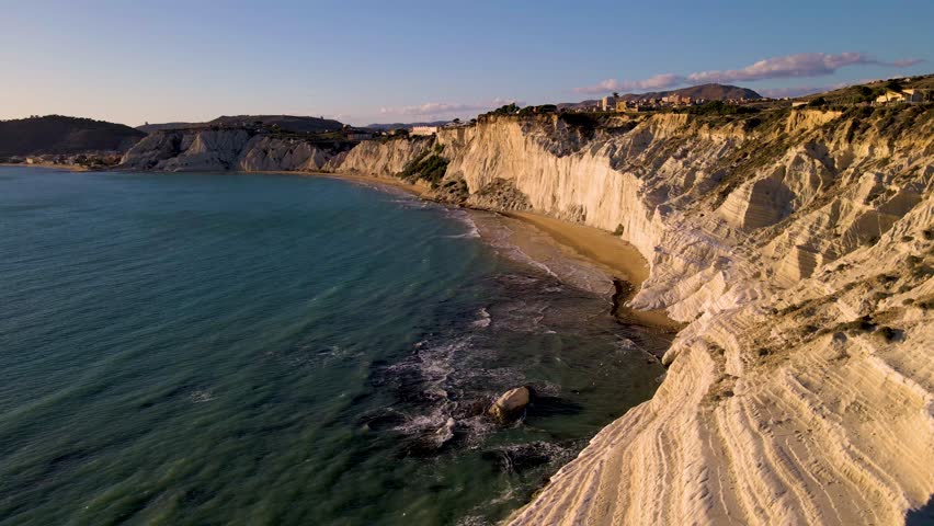 Experience the beauty of Sicily stunning coastline as the sun sets, illuminating the majestic cliffs and serene sandy beaches. Scala dei Turchi (Italy) The very famous white rocky cliff on the coast