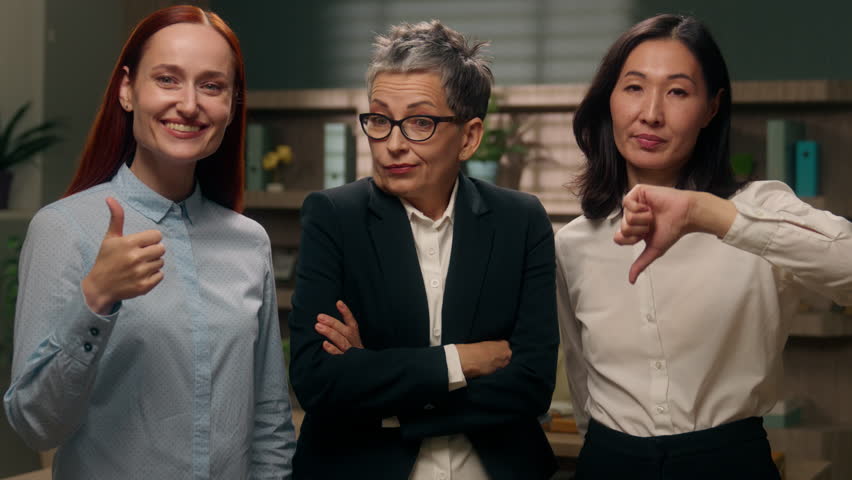 Three women showing thumbs up down gesture unsure unknown doubt choice employees office yes or no refusal approval question decision businesswomen business females girls positive negative boss choose