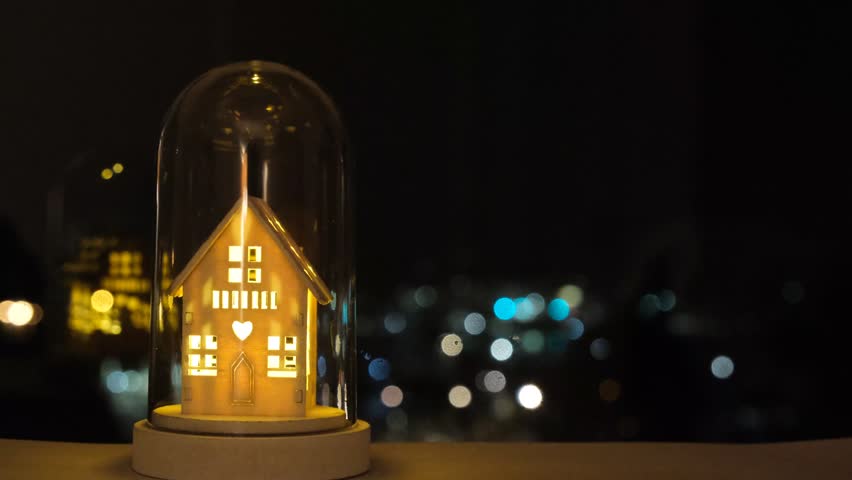 Fairy Christmas house with candlelight inside, background lights. Light up decoration, house shape with the bokeh lights on the dark background. Christmas mood, winter decoration on window