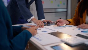 Businesswomen collaborating in a meeting room, analyzing financial graphs and charts on their desks - Powered by Shutterstock - Get 15% off with code: PIKWIZARD15
