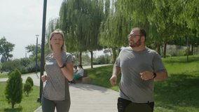 Obsessive man with trainer woman jogging in public park, trying to loss some weight. Healthy lifestyle with coach and special support - Powered by Shutterstock - Get 15% off with code: PIKWIZARD15