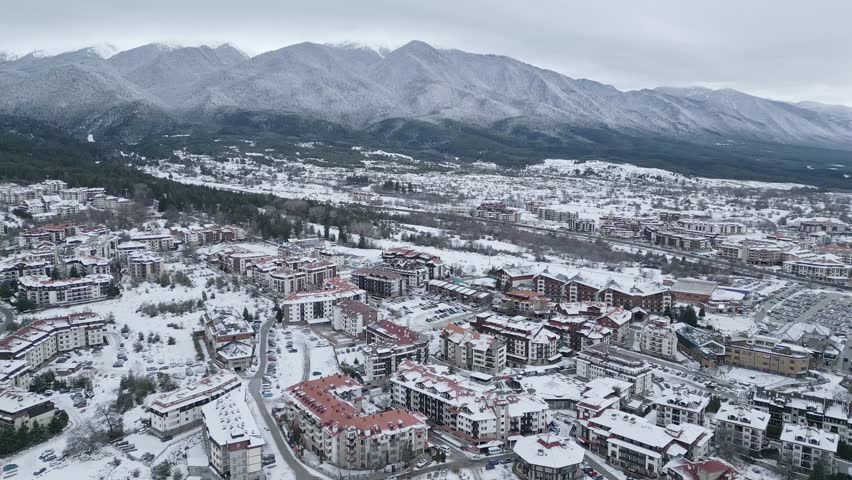 Snow-covered town surrounded by mountains in winter season captures the serene beauty of nature and architecture. Bansko, Bulgaria