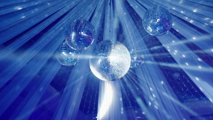 Bright disco ball spins and reflects colorful lights during a lively dance event at the evening A colorful disco mirror ball illuminates the backdrop of a nightclub. The party lights up the disco ball