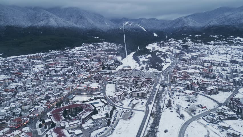Snow-covered mountain town under a cloudy sky during winter season. Bansko, Bulgaria