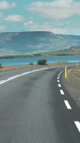 Car driving on the road to Iceland. View of the road, mountains and the bay from the inside of the car. Road number 1 is Iceland