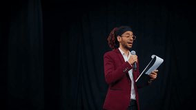 Stand-up comedy performance and presentation, portrait of male host on stage. Charismatic male person reading text and talking to microphone, stand-up comic rehearsing his performance in nightclub - Powered by Shutterstock - Get 15% off with code: PIKWIZARD15