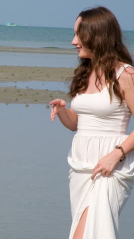 long white dress walk barefoot on water summer enjoy cool water lake shallow tropical country young woman