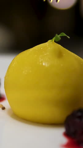 One Slice of homemade lemon curd cake in the shape of an ingot or brick, a jar with the lemon curd cream and some lemons in the background on an old wooden table.
