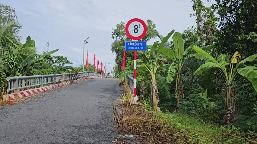 View of rural road and bridge sign  in Mang Thit district, Vinh Long province. Translation: "Kenh Tu bridge"