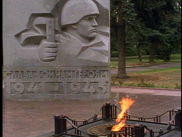 Russia, War Memorial, eternal flame, medium shot with granite bas relief of soldiers