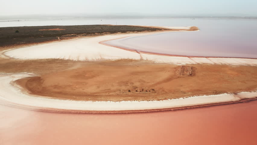Fantastic pink Torrevieja lake beach covered with salt bird eye view. Natural mineral deposits extraction at Spanish water resort on summer day