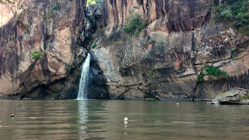 Chart Trakan waterfall parkland at Phitsanulok province - Thailand. High vertical waterfall that falling fron the rock cliff. Nature and environment scene 4K footage.