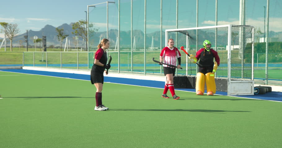 Female hockey players competing intensely on outdoor field, showcasing teamwork. Field hockey, competition, athletes, action, sport, dynamic