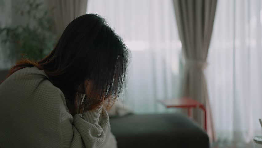 A young asian woman feeling depressed and stressed sitting head in hands, Lonely woman having life troubles