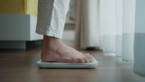 Close up a woman's bare feet stepping onto a digital weighing scale in the morning at home. Healthy lifestyle and weight awareness concept - Powered by Shutterstock - Get 15% off with code: PIKWIZARD15