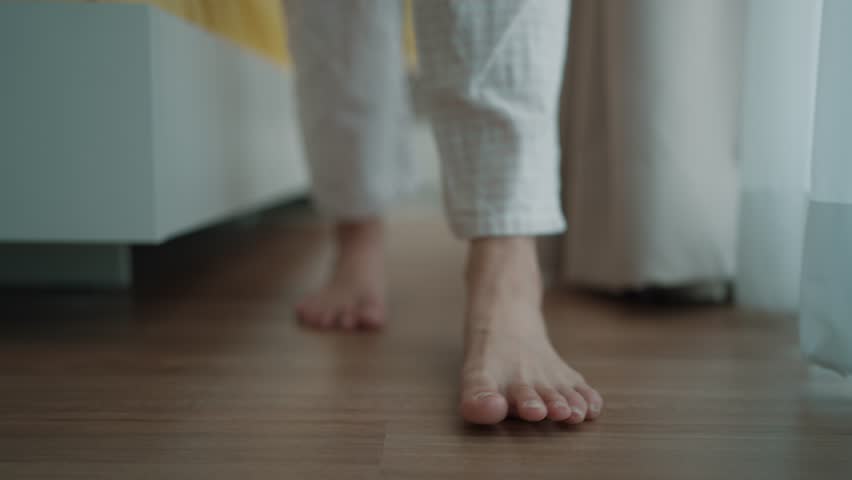 Close up a woman's bare feet stepping onto a digital weighing scale in the morning at home. Healthy lifestyle and weight awareness concept