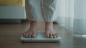 Close up a woman's bare feet stepping onto a digital weighing scale in the morning at home. Healthy lifestyle and weight awareness concept - Powered by Shutterstock - Get 15% off with code: PIKWIZARD15
