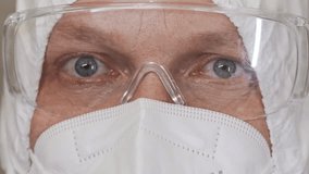 Close up of laboratory worker eyes wearing protective mask and safety goggles in sterile clinical environment. Medical safety and protection. - Powered by Shutterstock - Get 15% off with code: PIKWIZARD15
