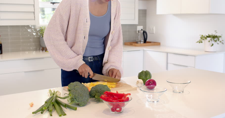 Indian woman chopping vegetables in modern kitchen, preparing healthy meal. Cooking, culinary, lifestyle, preparation, nutrition, domestic