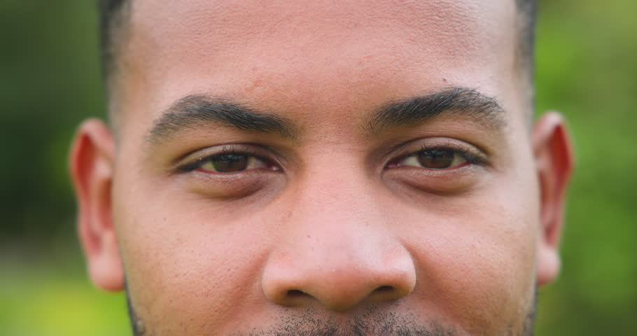 Close-up of man's face outdoors, focusing on eyes and expression. Portrait, emotion, male, contemplation, thoughtful