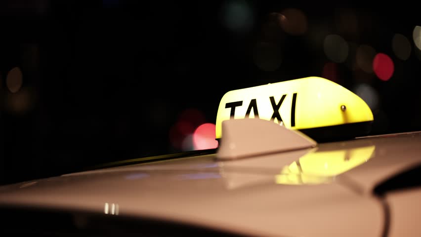 Taxi Roof Sign Light And Taxi Car Driving Around The Night City