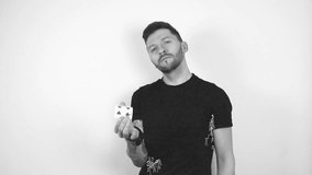 Grayscale footage of a tattooed man flipping and throwing playing cards into the air in slow motion making them fly and drop to the ground slowly. Man looks confident and looks into the camera. - Powered by Shutterstock - Get 15% off with code: PIKWIZARD15