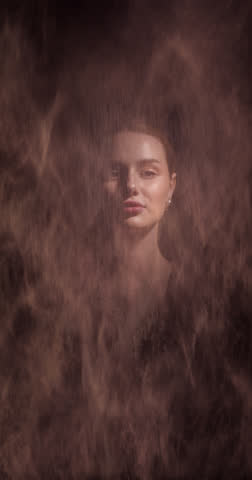 A stunning portrait of a woman enveloped in cascading sand. Dramatic lighting highlights her serene expression, creating an artistic and ethereal atmosphere.