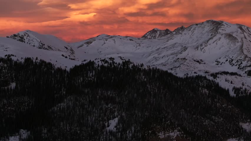 Glorious purple high elevation Rocky Mountains setting sunset orange vibrant cloudy skies Winter solstice Colorado aerial drone i70 Coon Hill Parshall Eisenhower tunnel Continental Divide forward pan