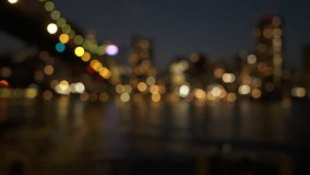 The blurred city lights create a stunning bokeh effect with warm, glowing orbs of color. Gentle reflections shimmer beautifully on the calm water surface, adding a dreamy atmosphere. - Powered by Shutterstock - Get 15% off with code: PIKWIZARD15