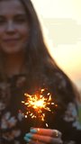 The couple dancing with firework sticks on an morning sunrise background. Super slow motion. Close-up of fireworks and sparklers. Re-focusing from sparklers to faces. Vertical shot. - Powered by Shutterstock - Get 15% off with code: PIKWIZARD15