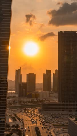 Colorful, golden sunset over Abu Dhabi, United Arab Emirates - city skyline vertical time lapse