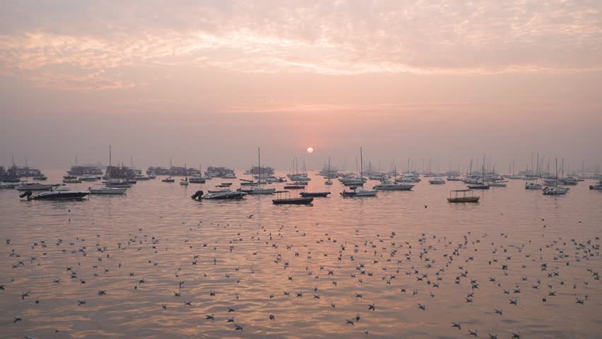 Early Morning Weather on the Seashore of Mumbai. Fishing boats sail in the sea during sunrise near Gateway Of India.