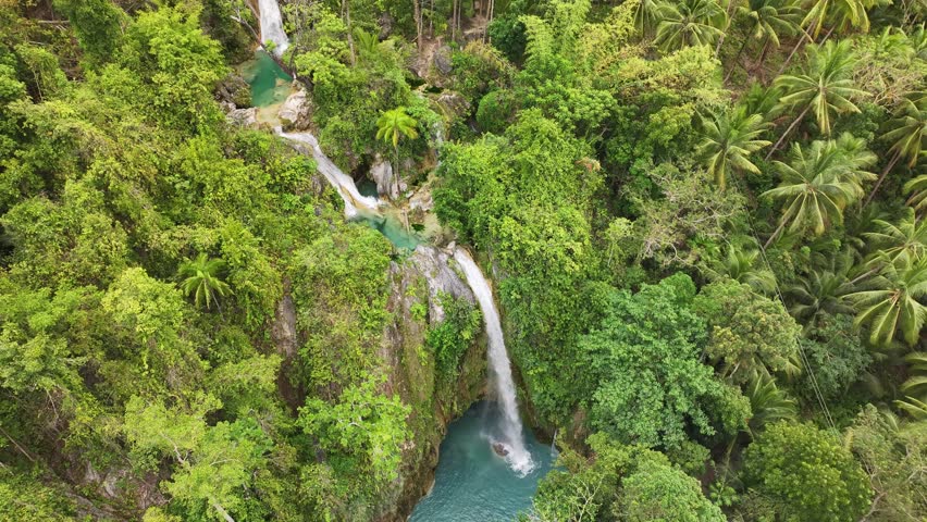Aerial view of inambakan falls surrounded by lush greenery and tropical forest, Ginatilan, Philippines.